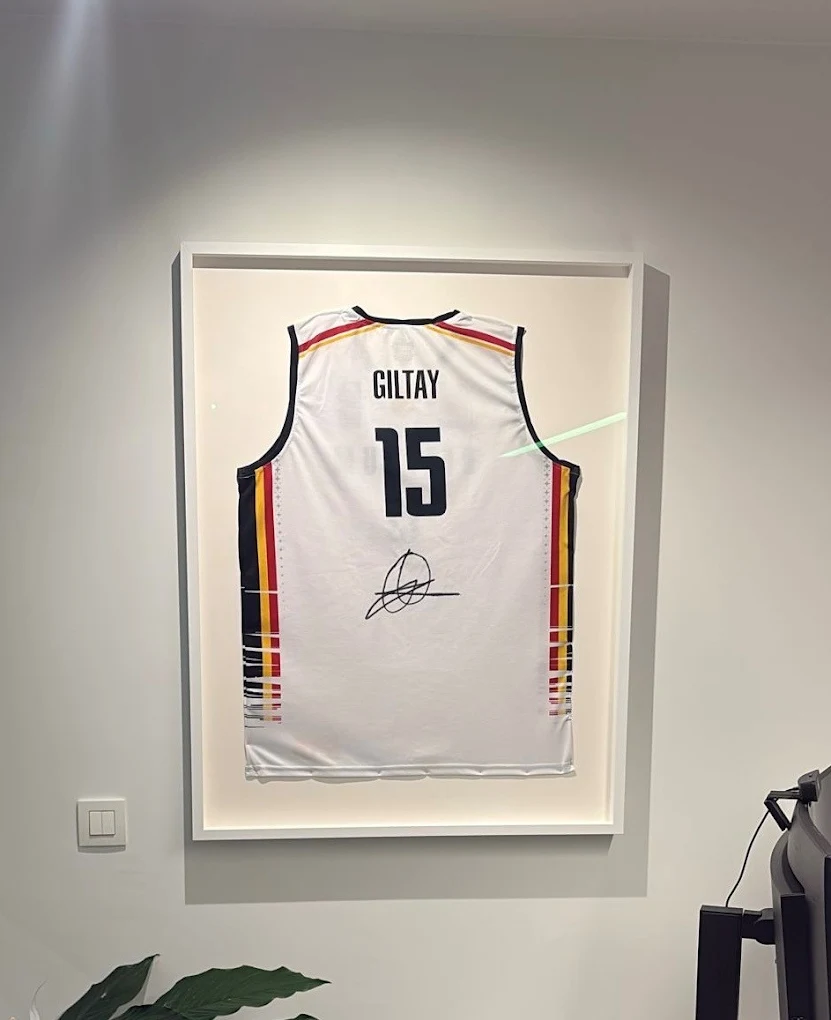Ingelijst wit basketbalshirt van de Belgian Lions (nummer 15) met handtekening, gepresenteerd in een modern wit kader